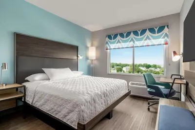 a bedroom with a bed and a chair and a window at Tru By Hilton Hershey Chocolate Avenue in Hershey
