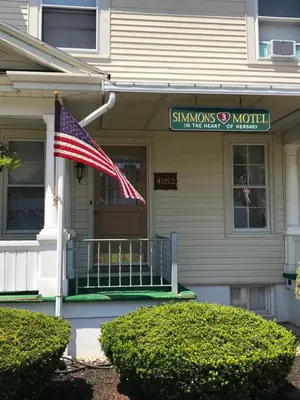 a house with an american flag on a porch at Simmons Motel and Suites in Hershey
