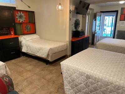 a hotel room with two beds and a tv at Simmons Motel and Suites in Hershey
