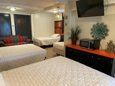 a hotel room with two beds and a tv at Simmons Motel and Suites in Hershey