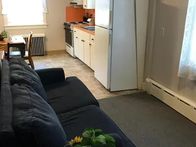 a living room with a couch and a kitchen at Simmons Motel and Suites in Hershey