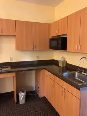 a kitchen with a sink and a microwave at Budget Inn Williamsport in Williamsport