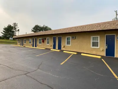 a building with blue doors and a parking lot at Dunmore Inn in Dunmore