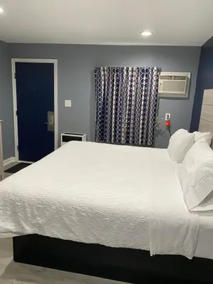 a large white bed in a room with a window at Dunmore Inn in Dunmore