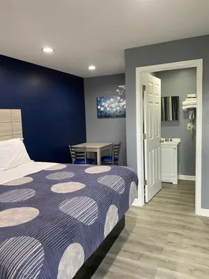 a bedroom with a bed and a table with chairs at Dunmore Inn in Dunmore