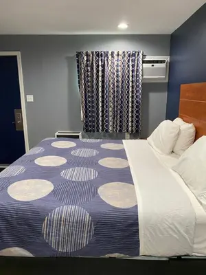 a hotel room with a large bed and a window at Dunmore Inn in Dunmore