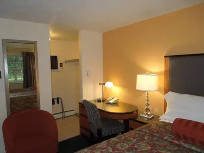 a hotel room with a bed and a desk with a phone at Sentinel Motel in West Chester