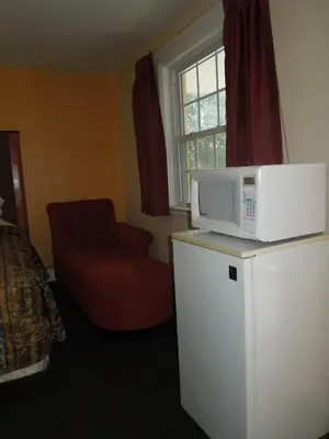 a room with a microwave on top of a refrigerator at Sentinel Motel in West Chester