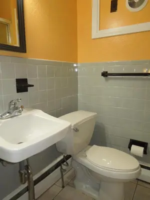 a bathroom with a white toilet and a sink at Sentinel Motel in West Chester
