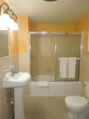 a bathroom with a shower and a sink and a toilet at Sentinel Motel in West Chester