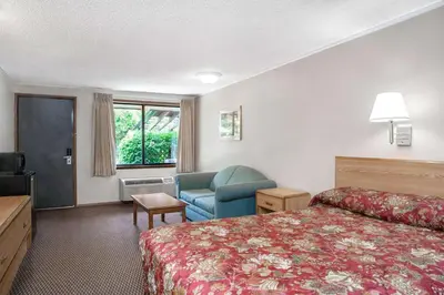 a hotel room with a bed and a chair at Knights Inn Pittston in Pittston