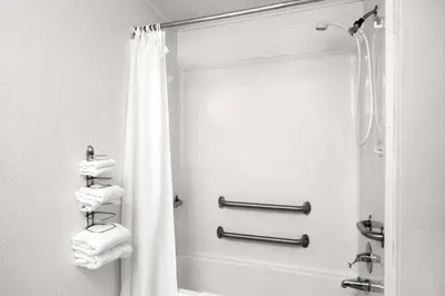 a bathroom with a shower and a white shower curtain at Knights Inn Pittston in Pittston