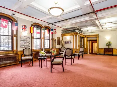 a large room with chairs and tables and flags at Leo House in New York