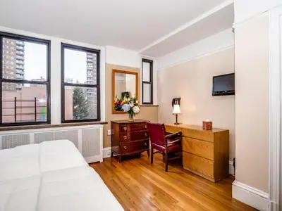 a bedroom with a bed and a desk with a chair at Leo House in New York