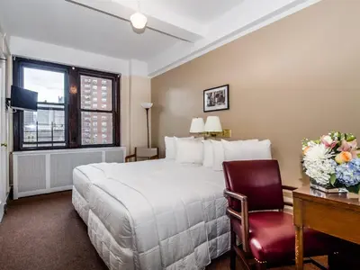 a hotel room with a bed and a desk and a chair at Leo House in New York