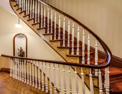 a staircase with wooden treads and white railings at Leo House in New York