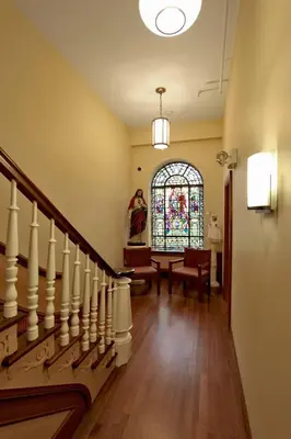 a hallway with a staircase and a stained glass window at Leo House in New York