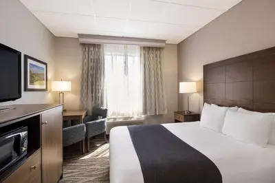 a hotel room with a bed and a flat screen tv at Best Western Lock Haven in Lock Haven