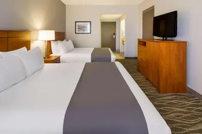 a hotel room with two beds and a flat screen tv at Best Western Lock Haven in Lock Haven