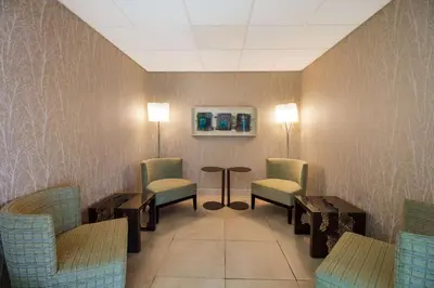 a waiting room with chairs and a table and lights at Best Western Lock Haven in Lock Haven