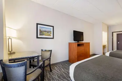 a hotel room with a bed and a desk and a tv at Best Western Lock Haven in Lock Haven