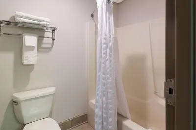 a white bathroom with a toilet and a shower at Best Western Lock Haven in Lock Haven