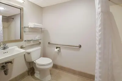 a bathroom with a toilet and a sink and a mirror at Best Western Lock Haven in Lock Haven