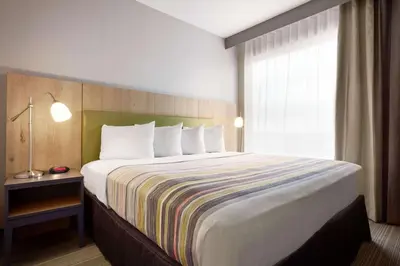 a large bed in a hotel room with a window at Country Inn & Suites by Radisson, York, PA in York