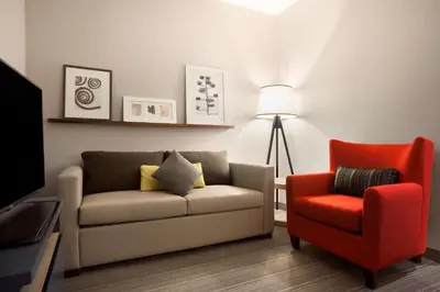 a living room with a couch and a red chair at Country Inn & Suites by Radisson, York, PA in York