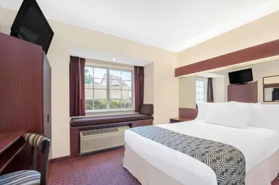 a hotel room with a bed and a window at Microtel Inn & Suites by Wyndham Hamburg in Hamburg