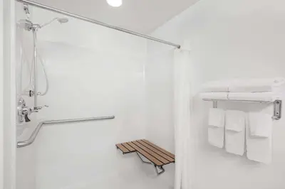 a bathroom with a shower and white towels at Microtel Inn & Suites by Wyndham Hamburg in Hamburg