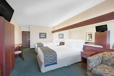 a hotel room with two beds and a television at Microtel Inn & Suites by Wyndham Hamburg in Hamburg