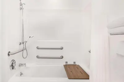 a bathroom with a bath tub with a wooden cutting board at Microtel Inn & Suites by Wyndham Hamburg in Hamburg