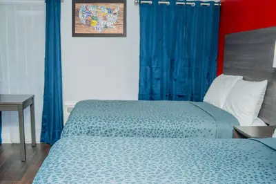a bedroom with two beds with blue drapes at Econo Lodge Clarks Summit - Scranton in Clarks Summit