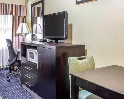 a hotel room with a desk with a tv and a table at Econo Lodge Clarks Summit - Scranton in Clarks Summit