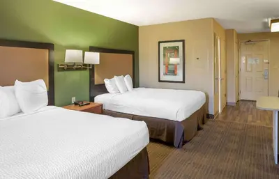 a hotel room with two beds and green walls at Extended Stay America Select Suites - Wilkes - Barre - Scranton in Wilkes-Barre