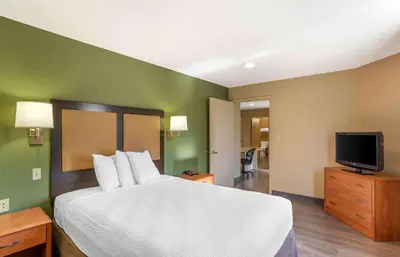 a hotel room with a large bed and a television at Extended Stay America Select Suites - Wilkes - Barre - Scranton in Wilkes-Barre
