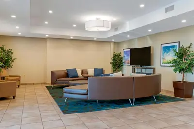 a lobby with a couch and a flat screen tv at Candlewood Suites Reading by IHG in Reading