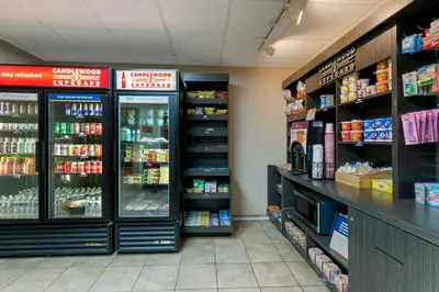 a store aisle with refrigerators and shelves of food at Candlewood Suites Reading by IHG in Reading