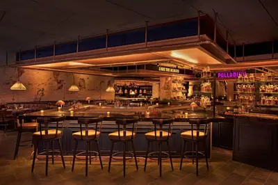 a bar with bar stools in a room at Moxy NYC East Village in New York