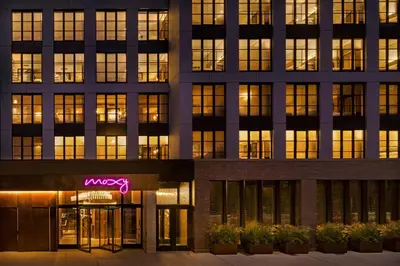 an office building with a neon sign in front of it at Moxy NYC East Village in New York