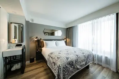 a bedroom with a bed and a sink and a mirror at Pestana Park Avenue in New York