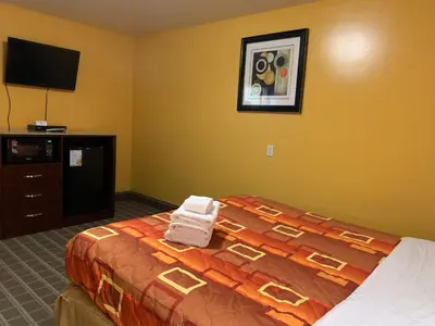 a bedroom with a bed and a flat screen tv at Scottish Inns Wrightstown in Wrightstown