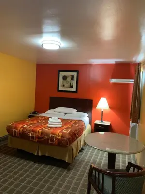 a hotel room with a bed and a table at Scottish Inns Wrightstown in Wrightstown