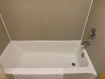 a white bath tub with a towel in a bathroom at Scottish Inns Wrightstown in Wrightstown
