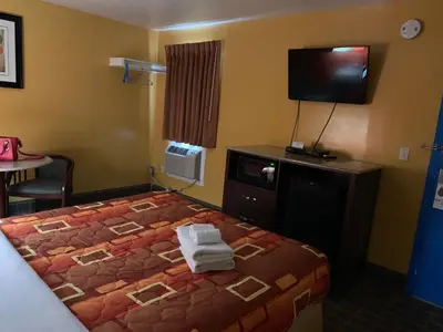 a hotel room with a bed and a flat screen tv at Scottish Inns Wrightstown in Wrightstown