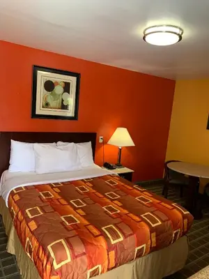 a hotel room with a bed and a table at Scottish Inns Wrightstown in Wrightstown