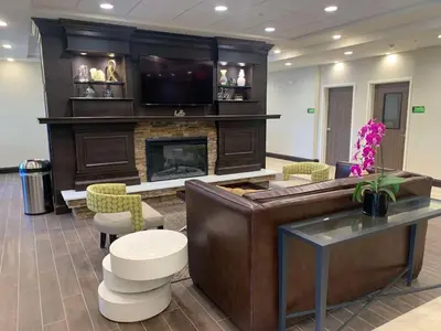a living room with a fireplace and a tv at Best Western Plus Horseheads - Elmira in Horseheads