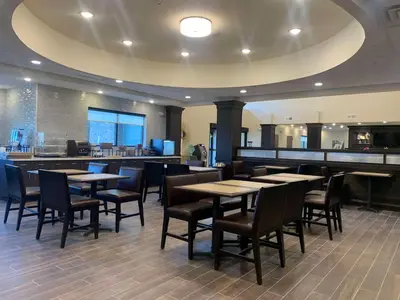 a restaurant with tables and chairs and a bar at Best Western Plus Horseheads - Elmira in Horseheads