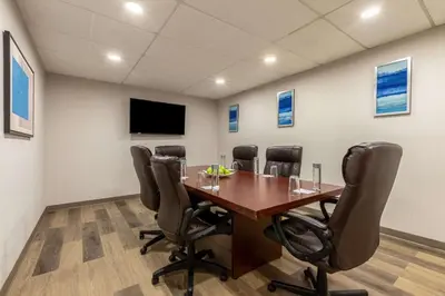 a conference room with a wooden table and chairs at The Hub Murray Hill, BW Premier Collection in New Providence
